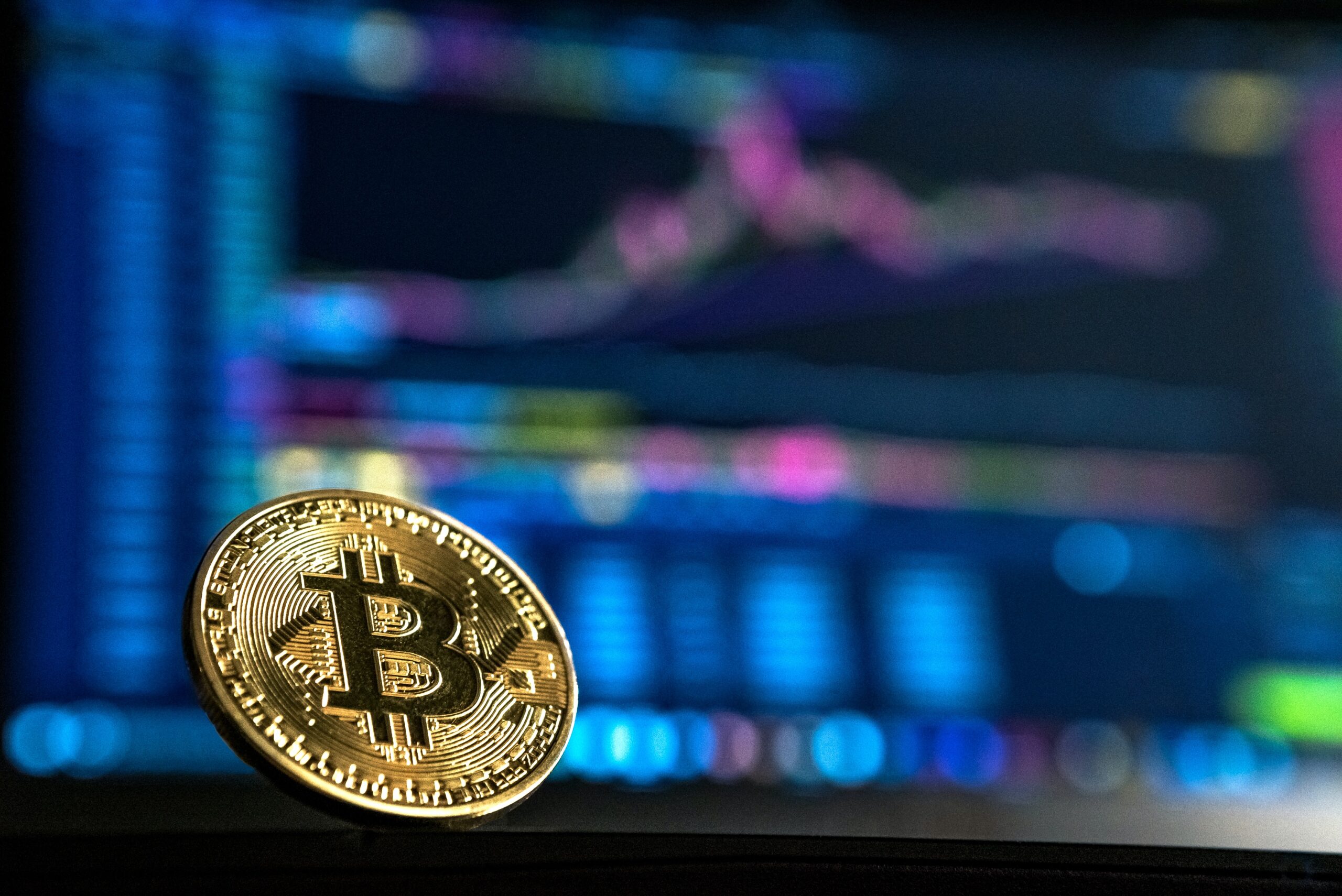 Bitcoin token against trading screens