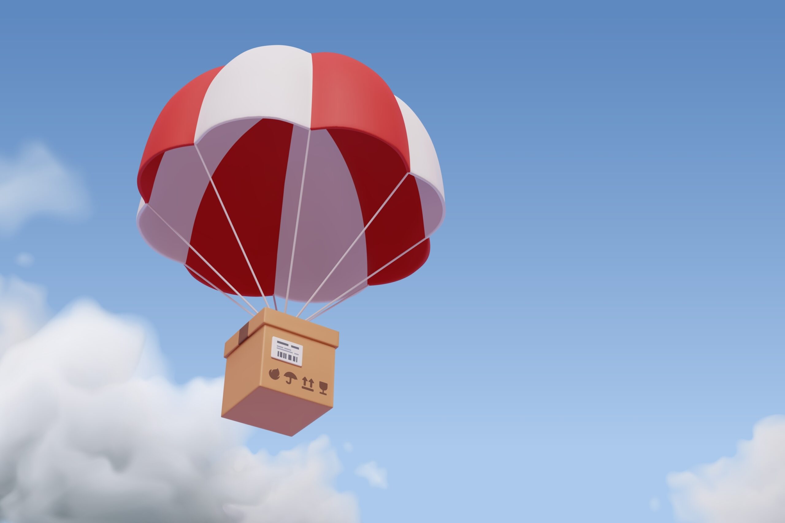 A package strung onto a white and red parachute (Shutterstock)